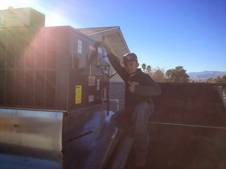 HVAC technician performing AC Tune-Up on a rooftop unit in Fountain